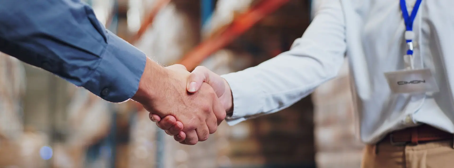 Two people shaking hands, one person has a CIMON tag